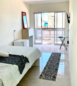 a bedroom with a bed and a table and a window at Pousada Piscinas Naturais in Porto De Galinhas