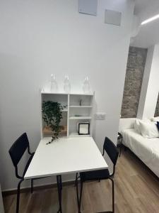 貝尼多姆的住宿－Apartamentos Rocablanca，一张白色的桌子和椅子,位于一个配有床的房间
