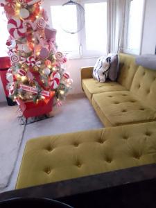 a living room with a christmas tree and a couch at Brittany's in Gisburn