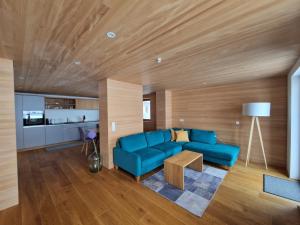 a living room with a blue couch and a table at Alphof Appartement Faschina in Fontanella