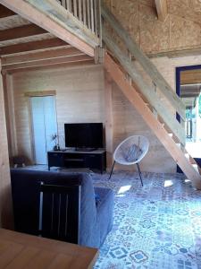 a living room with a couch and a tv at CHALETS POUR FAMILLE ET AMIS in La Chapelle-aux-Chasses