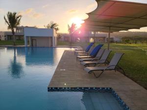 a row of lounge chairs sitting next to a swimming pool at Entire residential swahili home-Vipingo in Kikambala