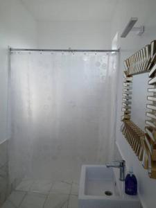 a white bathroom with a shower and a sink at Entire residential swahili home-Vipingo in Kikambala