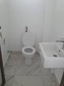 a bathroom with a white toilet and a sink at Entire residential swahili home-Vipingo in Kikambala
