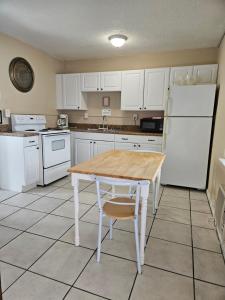 a kitchen with a wooden table and a white refrigerator at Oasis Palms Resort in St. Pete Beach
