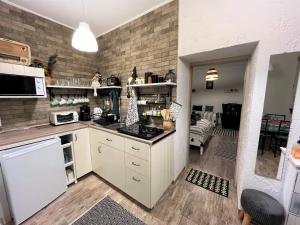 cocina con electrodomésticos blancos y sala de estar. en Ladislaus Schnaps-Haus Falusi Vendégház, en Csolnok
