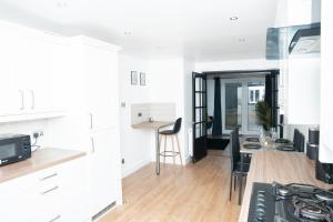 a kitchen and living room with a table and chairs at Stylish 3 bed house with free parking in Belle Isle