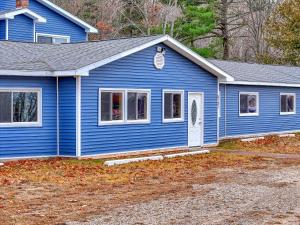 una casa azul con una puerta blanca en The Blue Anchor Unit #1, en Houghton Lake