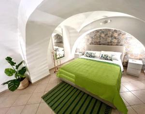 sypialnia z zielonym łóżkiem w łuku w obiekcie Ursino holiday apartment w Katanii