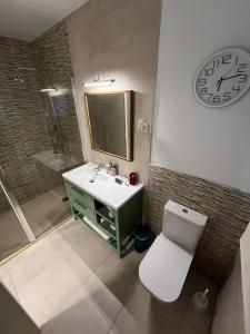 a bathroom with a sink and a clock on the wall at Habitación independiente, luminosa y perfecta para dos o una persona. in Montequinto