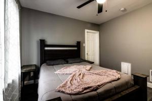 ein Schlafzimmer mit einem Bett mit einer Decke darauf in der Unterkunft Comfortable 3BR, 1 Bath close to the falls in Niagara Falls