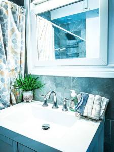 um lavatório de casa de banho com um espelho e uma janela em Comfortable 3BR, 1 Bath close to the falls em Niagara Falls