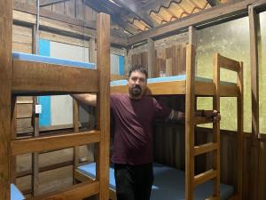 a man standing in the middle of a bunk bed at Granja Integral Luz Del Corazon 