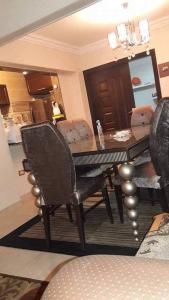 a dining table and chairs in a living room at شقه مفروش في التجمع الخامس in Cairo