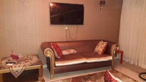 a living room with a brown leather couch and a table at شقه مفروش في التجمع الخامس in Cairo