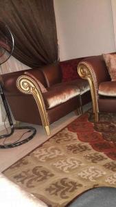 a brown leather couch in a living room with a rug at شقه مفروش في التجمع الخامس in Cairo