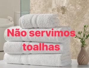 uma pilha de toalhas com as palavras naya service em Moria em Goiânia