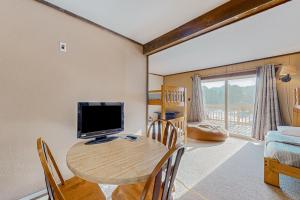 uma sala de estar com uma mesa de madeira e uma televisão em Alpine Horn Lodge at Big Powderhorn Mountain - Unit B em Ironwood