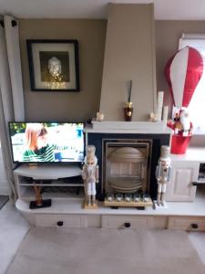 a living room with a tv and a fireplace at Brittany's in Gisburn