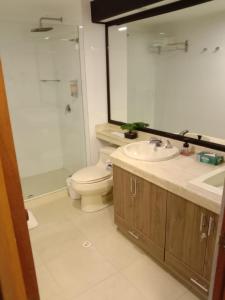 y baño con aseo, lavabo y espejo. en Acogedor Apartasuite cerca al Parque de la 93, en Bogotá