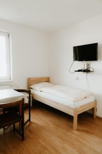 een kamer met 2 bedden en een flatscreen-tv bij Penzión Enbra 