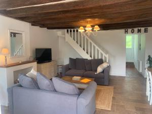 Sala de estar con 2 sofás y mesa en Les Bocages, gîtes de charme en Val de Loire, piscine chauffée, en Monteaux