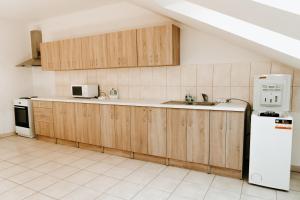 een keuken met houten kasten en een witte koelkast bij Penzión Enbra 