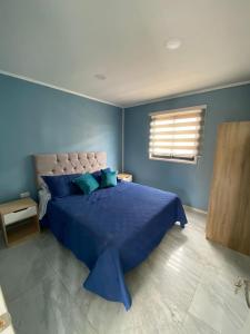 1 dormitorio azul con 1 cama grande con sábanas azules en Casas el Quisco norte, en El Quisco