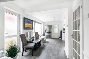 a living room with white walls and a table and chairs at Hampton Oasis with Heated Pool & Large Garden in Molesey