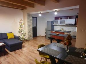 Domček pod lesíkom في بانسكا شتيفنيتسا: غرفة معيشة مع شجرة عيد الميلاد وأريكة زرقاء
