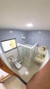 a bathroom with a glass sink and a toilet at Blue House Vale do Capão in Palmeiras