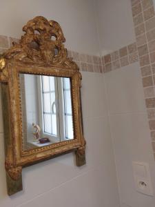 un miroir ornementé sur un mur dans la salle de bains dans l'établissement Studio Fontaine d’amour, à Sarlat-la-Canéda