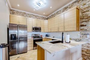 una cocina con armarios de madera y electrodomésticos de acero inoxidable en Desert Cottage, en Fountain Hills