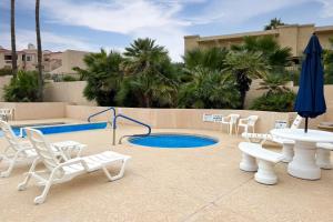 un patio con mesa, sillas y piscina en Desert Cottage en Fountain Hills