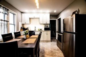 a kitchen with a table and a stainless steel refrigerator at Quaint 3BR, 1 Bath near the falls in Niagara Falls