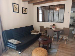 a living room with a couch and a table at Studio Fontaine d’amour in Sarlat-la-Canéda