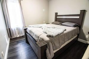 a bedroom with a large bed with a wooden headboard at Quaint 3BR, 1 Bath near the falls in Niagara Falls