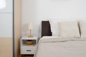 a bedroom with a white bed with a side table at Ferienwohnung Rheinauen in Germersheim