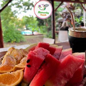 a plate of watermelon and orange slices and a drink at Mainumby- Colibri Posada in Puerto Iguazú