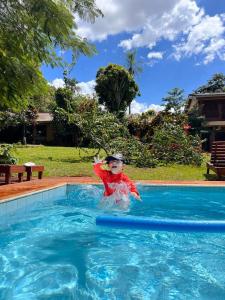 a young boy is in a swimming pool at Mainumby- Colibri Posada in Puerto Iguazú