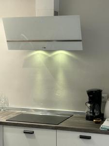 a kitchen with a counter top with a white hood at Apartments Oliva in Poreč
