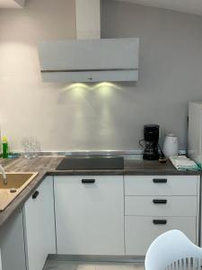 a kitchen with white cabinets and a stove top oven at Apartments Oliva in Poreč
