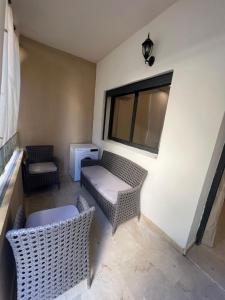 uma sala de estar com mobiliário de vime e uma janela em Appart prestige de luxe em Marrakech