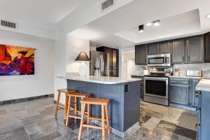 a kitchen with a counter and two stools at Hidden Bloom Sanctuary in Litchfield Park