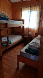 a room with two bunk beds and a window at Cabañas Canto del Tiuque in Pishuinco