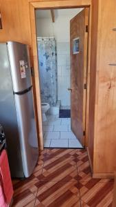 een kleine badkamer met een koelkast en een douche bij Cabañas Canto del Tiuque in Pishuinco