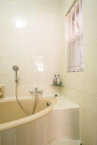 bagno con vasca e finestra di Hillview Holiday Condo a Harare