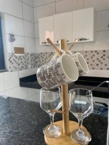 two wine glasses on a wooden stand in a kitchen at Apto Serras Gerais in Dianópolis