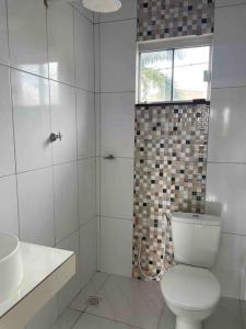 a white bathroom with a toilet and a shower at Apto Serras Gerais in Dianópolis