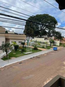una calle vacía al lado de un edificio con un árbol en Apto Serras Gerais, en Dianópolis
